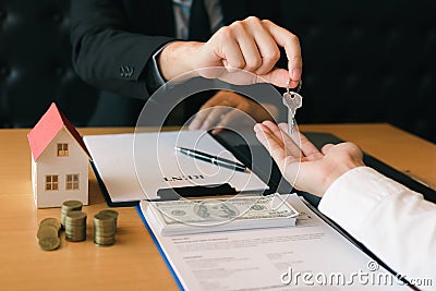 Salesman house brokers provide key to new homeowners in office Stock Photo