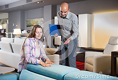 Salesman offering furniture variants to woman in salon Stock Photo