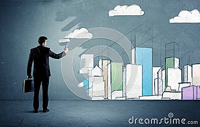 Salesman painting tall buildings on urban wall Stock Photo