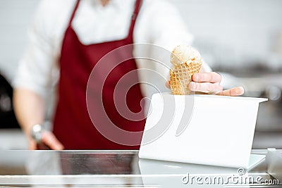 Salesman putting ice cream on the showacse Stock Photo