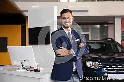 Salesman standing in modern auto dealership Stock Photo