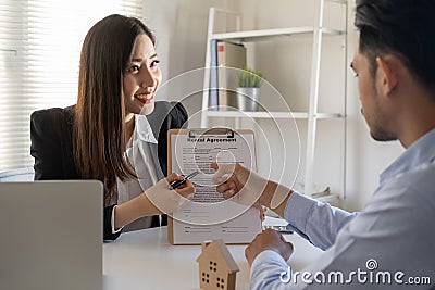 Salesman a women give advice about buying a house for male customers in the office Stock Photo