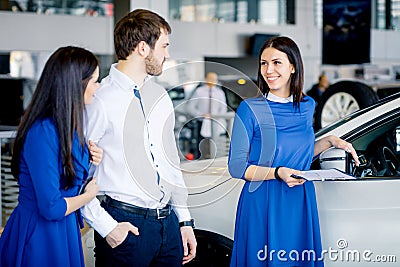 Salesperson advising and selling cars at car dealership Stock Photo