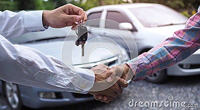 The salesperson held the key and handed it to the customer after the deal was successful. Ideas for renting a car or buying a car Stock Photo