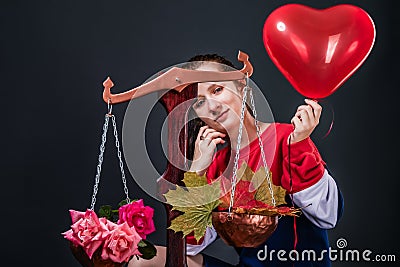 Saleswoman of beautiful autumn mood with colorful maple leaves, flowers and a heart shaped balloon Stock Photo