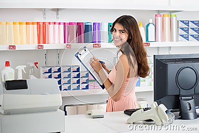 Saleswoman With Clipboard Taking Produce Inventory In Market Stock Photo