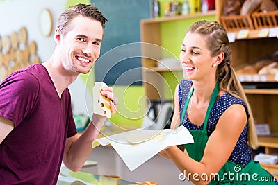 Saleswoman at counter offering cheese Stock Photo