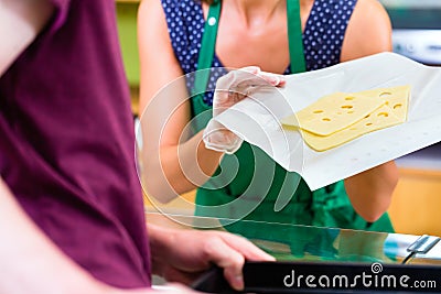 Saleswoman at counter offering cheese Stock Photo