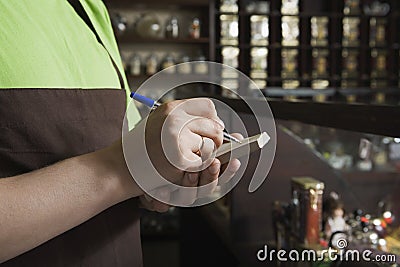 Saleswoman Writing Order In Book At Tea Shop Stock Photo