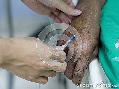 Saline intravenous IV drip on patient hand in hospital. Stock Photo