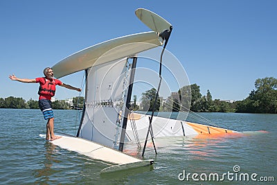 Salior trying to right catamaran after capsize Stock Photo