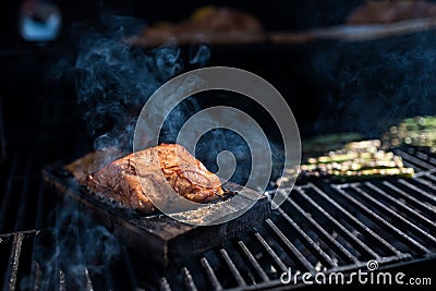 Salmon on an apple wooden plank on the grill Stock Photo