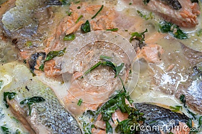 Salmon in a pan with parsley. Salmon in cream sauce is fried in a frying pan . close-up Stock Photo