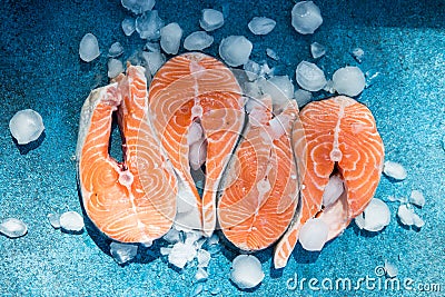 Salmon. Raw Trout Red Fish Steak served with Herbs and Ice on blue stone. Cooking Salmon, sea food. Healthy eating concept. Stock Photo