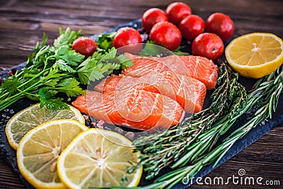 salmon steakes with greenery, lemon and cherry tomatoes Stock Photo