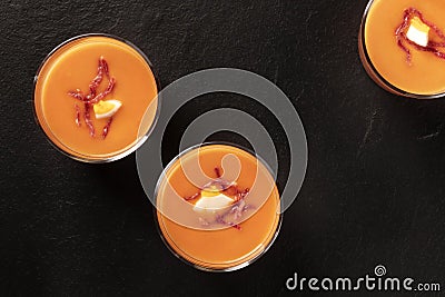Salmorejo, Spanish cold tomato and bread soup, in glasses, shot from the top on a black background Stock Photo