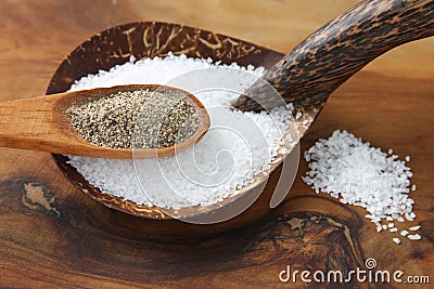 Salt and Pepper in Wooden Spoons Stock Photo