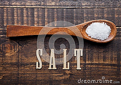 Salt on wooden spoon with letters below Stock Photo