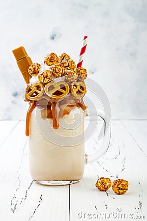 Salted caramel indulgent extreme milkshakes with brezel waffles, popcorn and whipped cream. Crazy freakshake trend Stock Photo