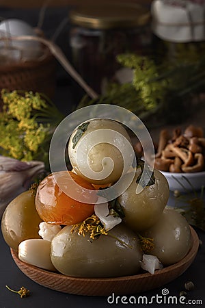 Salted tomatoes in a wooden plate on a background of fermented foods Stock Photo