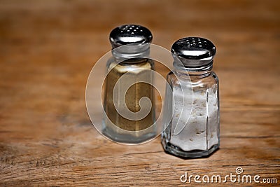 Saltshaker and pepper shaker on a wooden table. Stock Photo