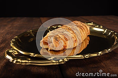 Salty bread stuffed with cheese and ham on a golden tray. Selective focus Stock Photo