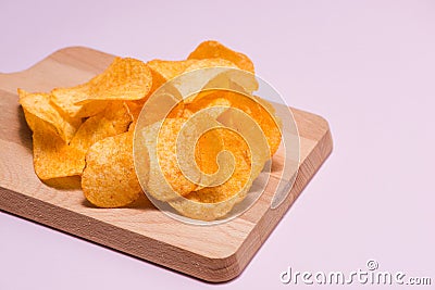 Salty crispy potato chips on cutting board. Stock Photo