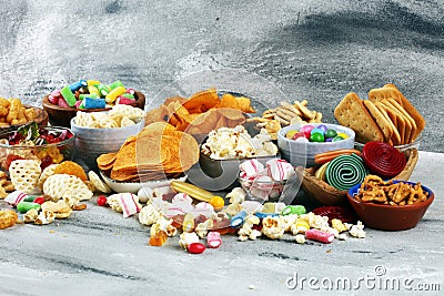 Salty snacks. Pretzels, chips, crackers and candy sweets on table Stock Photo