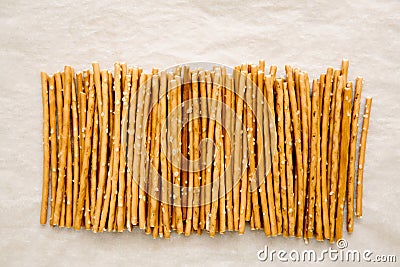 Salty sticks lie in row on light background, top view. Snack. Stock Photo