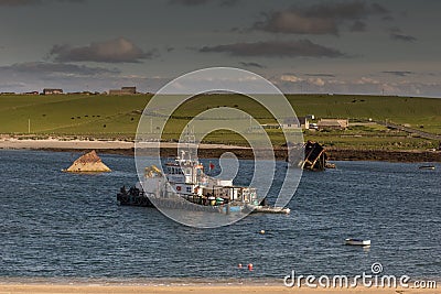 Salvage boat among pieces of shipwreck. Editorial Stock Photo