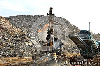 Salvaging and recycling building and construction materials. Excavator with hydraulic hammer work at landfill with concrete Stock Photo