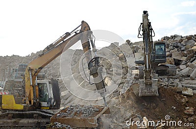 Salvaging and recycling building and construction materials. Excavator with hydraulic hammer work at landfill with concrete Editorial Stock Photo