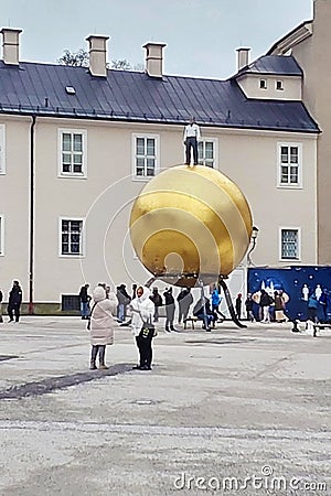 Golden sphere with a man - sculptor Stephan Balkenhol on Kapitelplatz square in Salzburg, Austria Editorial Stock Photo