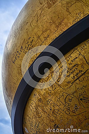 Golden sphere sculpture by Stephan Balkenhol on Kapitelplatz square in Salzburg Editorial Stock Photo