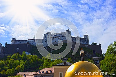 Salzburg, Austria - May 01, 2017: The golden ball statue with a man on the top sculpture, Kapitelplatz Square, Salzburg, Editorial Stock Photo