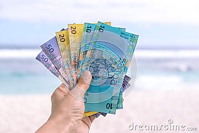 Samoan Tala currency - left hand holding bank notes from Western Stock Photo