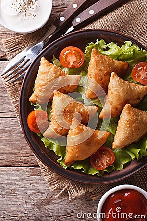Samosa on a plate with sauce closeup, vertical top view Stock Photo