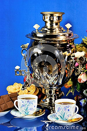 Samovar-tea drinking from cups, sweet food cookies and chocolate. Samovar represents well-being, family comfort and prosperity, a Stock Photo