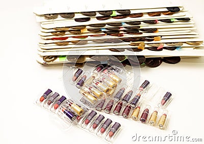 Swatches of colored strands on a white table with lipstick swatches Stock Photo
