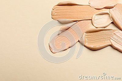 Samples of skin foundation on beige background, closeup. Space for text Stock Photo