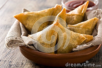 Samsa or samosas with meat and vegetables on wooden table. Traditional Indian food Stock Photo