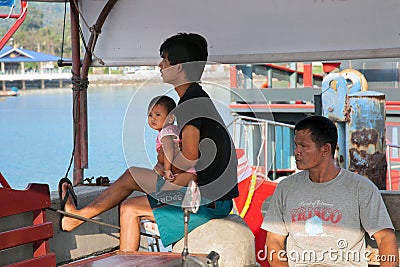 SAMUI, THAILAND - JANUARY 20,2011: Two Thai men and a boy waiting for a ship at the pier Editorial Stock Photo