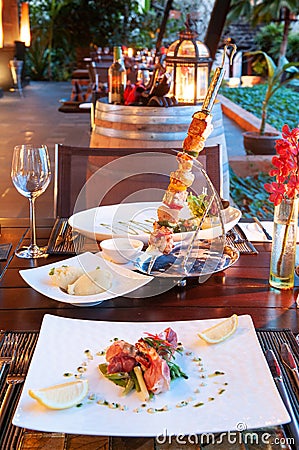 Luxury resort restaurant dinner table setting with barbecue and Stock Photo