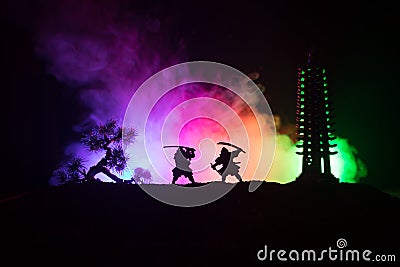 Samurai fighting concept. Silhouette of samurais in duel near tree and old temple. Picture with two samurais and sunset sky. Selec Stock Photo