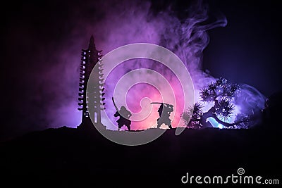 Samurai fighting concept. Silhouette of samurais in duel near tree and old temple. Picture with two samurais and sunset sky. Selec Stock Photo