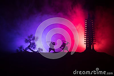 Samurai fighting concept. Silhouette of samurais in duel near tree and old temple. Picture with two samurais and sunset sky. Selec Stock Photo