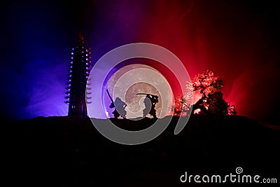 Samurai fighting concept. Silhouette of samurais in duel near tree and old temple. Picture with two samurais and sunset sky. Selec Stock Photo