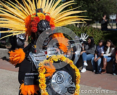SAN ANTONIO, TEXAS - OCTOBER 29, 2017 - Masked man wears feather deaddress and costume dances at the celebration of Dia de Los Mu Editorial Stock Photo