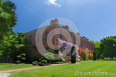 San Carlos, California, USA - May 05, 2019: Filoli estate in spring time with purple wisteria climbing on the brick walls Editorial Stock Photo