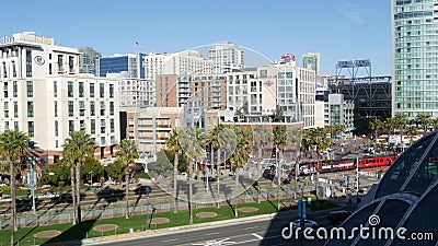SAN DIEGO, CALIFORNIA USA - 13 FEB 2020: MTS red trolley and metropolis urban skyline, highrise skyscrapers in city downtown. From Editorial Stock Photo
